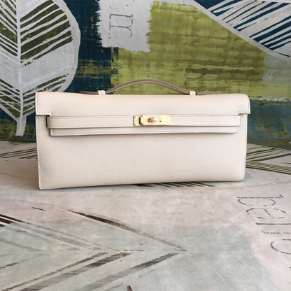 Soft Creamy Off-White Crosshatch Grain Slim Elongated Hand Clutch With Taupe Trim, Polished Golden Twist Lock Hardware And Curved Mini Top Carry Grip