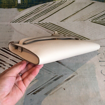 Soft Creamy Off-White Crosshatch Grain Slim Elongated Hand Clutch With Taupe Trim, Polished Golden Twist Lock Hardware And Curved Mini Top Carry Grip