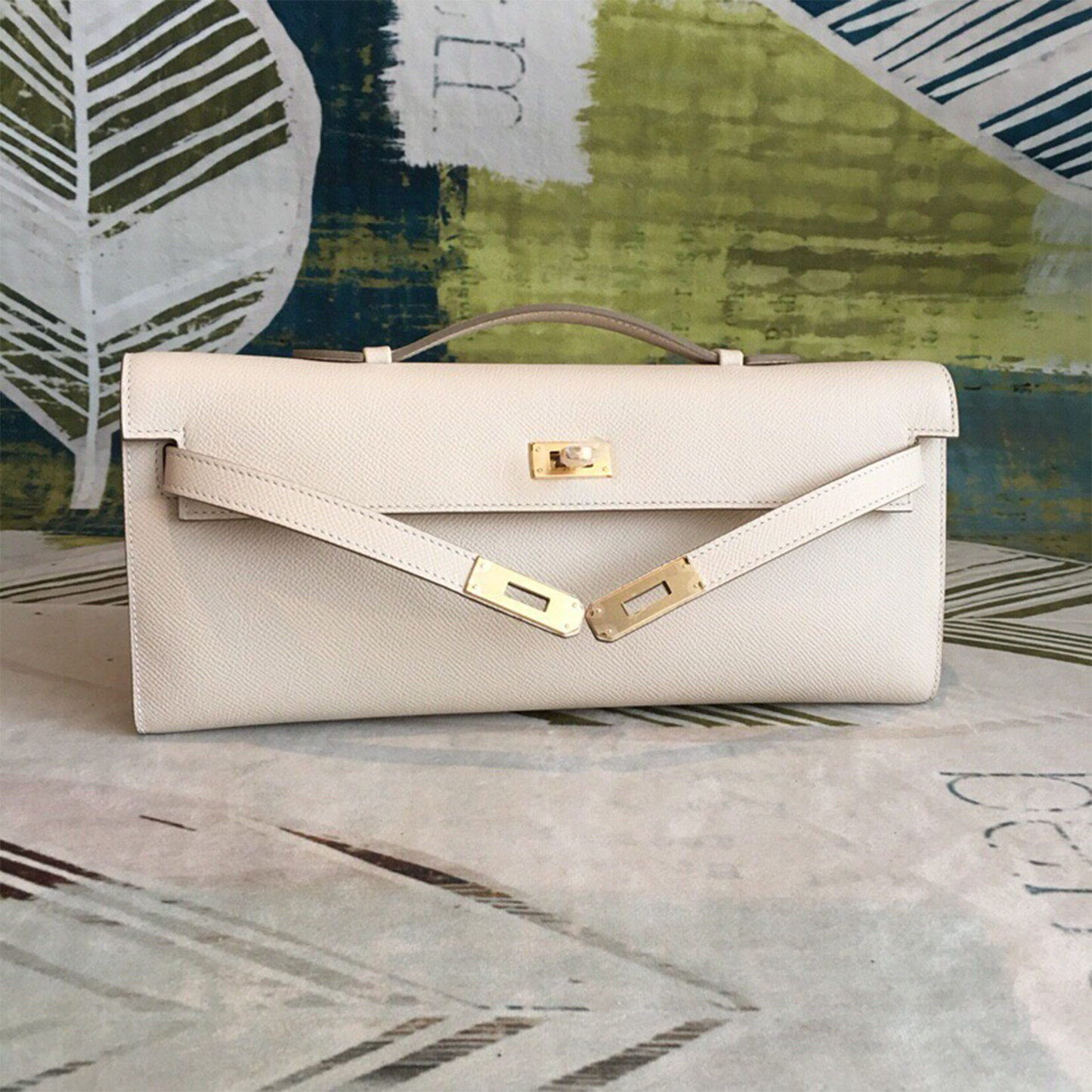 Soft Creamy Off-White Crosshatch Grain Slim Elongated Hand Clutch With Taupe Trim, Polished Golden Twist Lock Hardware And Curved Mini Top Carry Grip